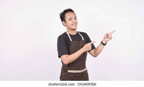 The man wearing the apron stands on a white background a pointing