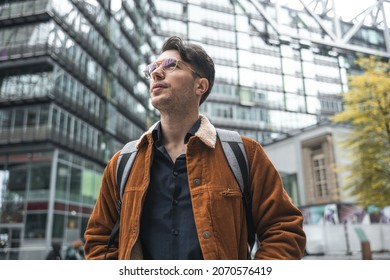 Man wearing backpack enjoying of the views of city while walking at the new place - Shutterstock ID 2070576419