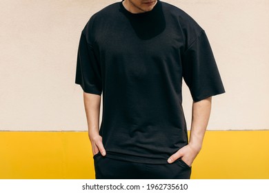 Man wearing black blank t-shirt with space for your logo or design. Mock up - Shutterstock ID 1962735610