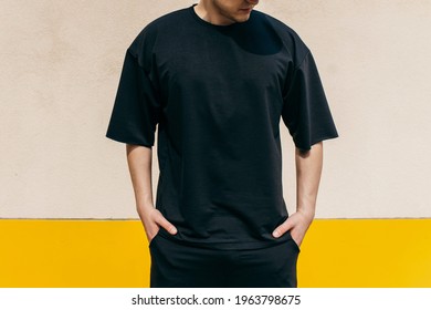 Man wearing black blank t-shirt with space for your logo or design. Mock up - Shutterstock ID 1963798675