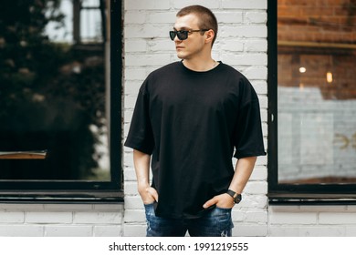 Man wearing black blank t-shirt with space for your logo or design. Mock up - Shutterstock ID 1991219555