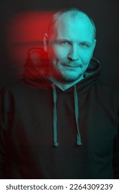 Man wearing black hoodie sweatshirt with laces portrait. Model looking at camera. Red and blue color split effect. Futuristic looking style. Black and white with 3D glitch virtual reality effect