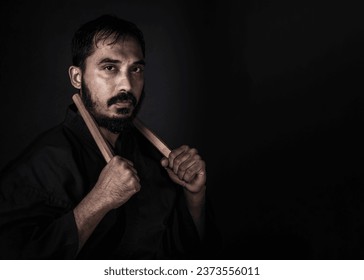 MAN WEARING BLACK MARTIAL ARTS GI KARATE  THEME SPACE FOR YOUR TEXT  - Powered by Shutterstock