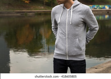 Man Wearing Blank Grey Hoodie, In The Urban Background Near The River