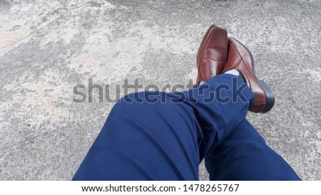 Man wearing blue pants and brown leather shoes and relax , soft focus , blurred.