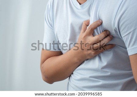 A man wearing a blue shirt has chest pain.
