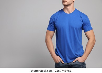 Man wearing blue t-shirt on light grey background, closeup. Mockup for design - Powered by Shutterstock