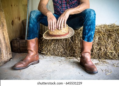 Man wearing boots sitting in barn