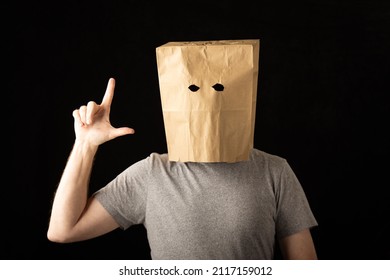 Man Wearing A Brown Paper Bag Over His Head And Making A Loser Symbol