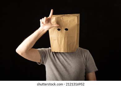 Man Wearing A Brown Paper Bag Over His Head And Making A Loser Symbol