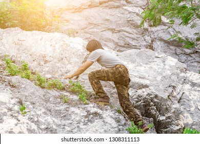 Man Wearing Cargo Pants And Climbing On The Rock