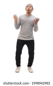 Man Wearing Casual Grey Shirt Black Denim And White Shoes, Excited Surprised Shocked And Happy Anticipating Something Amazing From Above. Soft Focus Full Body Portrait Isolated Cut Out