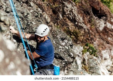 Man Wearing A Climbing Hamlet, Climbing On The Rock.