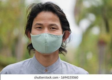 Man wearing a cloth mask in public area protect himself from risk of disease, people prevent infection from coronavirus Covid-19 or Air pollution