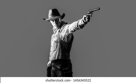 Man wearing cowboy hat, gun. West, guns. Portrait of a cowboy. owboy with weapon on red background. American bandit in mask, western man with hat. Portrait of farmer or cowboy in hat. Black and white.
