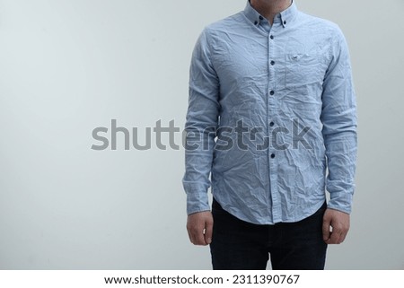 Man wearing creased shirt on light background, closeup. Space for text