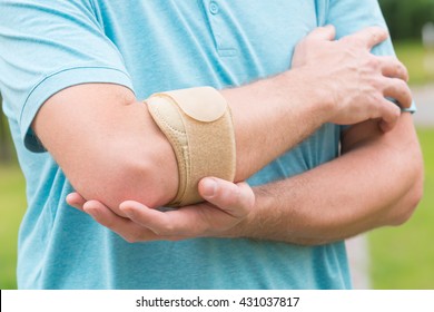 Man Wearing Elbow Brace To Reduce Pain