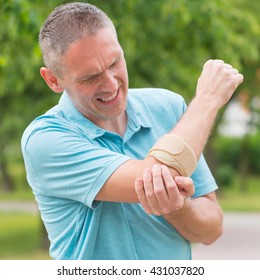 Man Wearing Elbow Brace To Reduce Pain