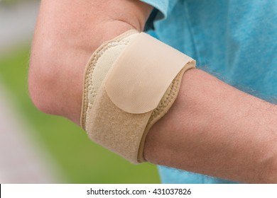 Man Wearing Elbow Brace To Reduce Pain