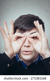 man wearing eye glasses made with fingers - Shutterstock ID 271381568