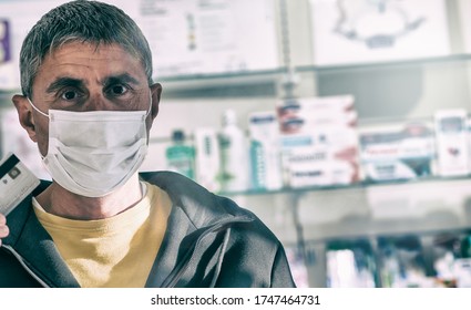 Man Wearing Face Mask In The Pharmacy. Coronavirus Emergency. Paying By Credit Card.