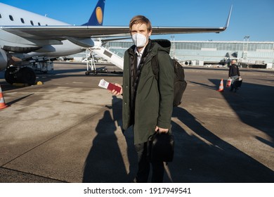 A Man Wearing Face Mask While Standing Next To Airplane With Passport. New Normal Traveling During A Pandemic. Male Passenger Traveling By Plane. Wearing Mask In Aircraft Cabin. Air Travel Covid 19