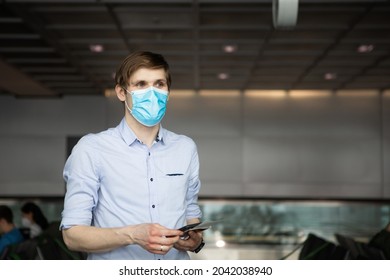 A Man Wearing Face Mask While Standing Airport With Passport. New Normal Traveling During A Pandemic. Male Passenger Traveling By Plane. Wearing Mask In Aircraft Cabin. Air Travel Covid 19