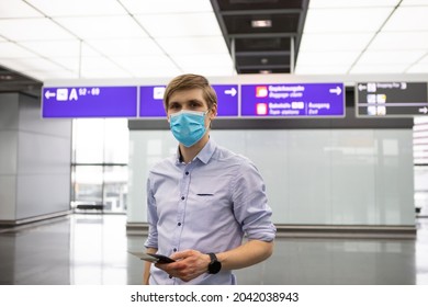 A Man Wearing Face Mask While Standing Airport With Passport. New Normal Traveling During A Pandemic. Male Passenger Traveling By Plane. Wearing Mask In Aircraft Cabin. Air Travel Covid 19