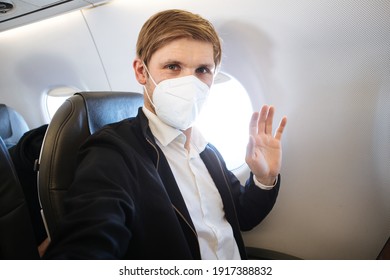 A Man Wearing FFP2 Face Mask While Sitting Into An Airplane. New Normal Traveling During A Pandemic. Male Passenger Traveling By Plane. Wearing Mask In Aircraft Cabin Air Travel Covid 19 Public Health