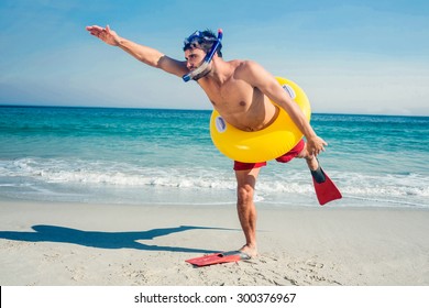 Man Wearing Flippers And Rubber Ring At The Beach On A Sunny Day