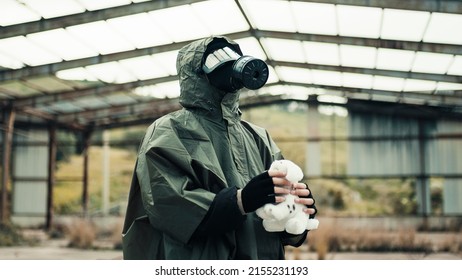 Man Wearing A Gas Mask Finds A Stuffed Animal In A War-torn Hospital