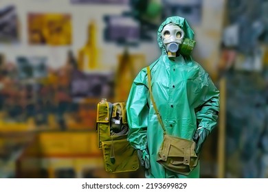 Man Wearing Gas Mask  And Radiation Protection Suit Standing Infront Of Factory. Background Out Of Focus
