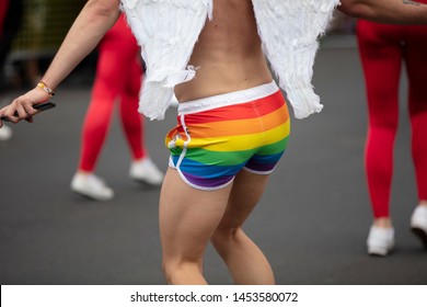 A Man Wearing Gay Pride Flag Shorts Dancing In The Street At A Pride Event