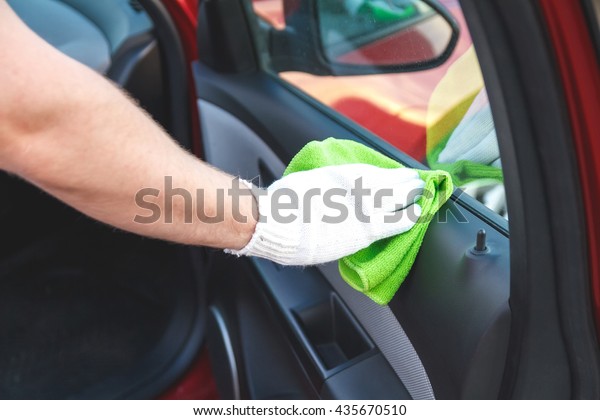 Man wearing gloves to clean the dashboard of the\
car. Auto Service