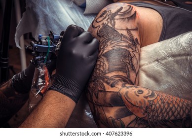 Man Wearing Gloves At Work In Tattoo Parlor