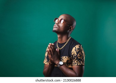 Man Wearing Gold Teeth Jewellery, Also Known As Teeth Grillsteeth Slugs, Photographed Against A Dark Green Background.