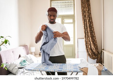 Man Wearing Headphones Preparing To Ironing Clothes With Pleasure Smile