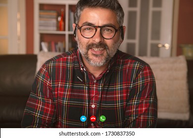 Man Wearing Headphones While Chatting On A Video Call - Person Having Fun Using A Technology Platform During Quarantine Isolation