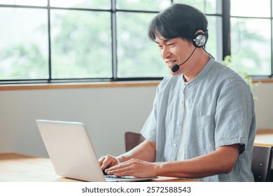 A man wearing a headset using a computer