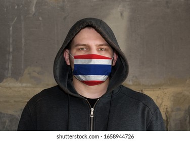 Man Wearing a hood and a Thailand flag Mask to Protect him virus.