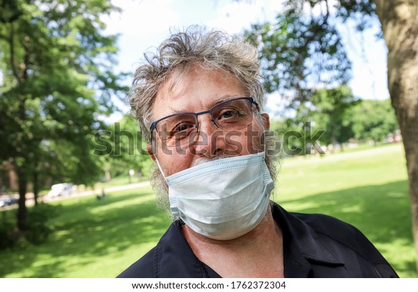 Man wearing mask incorrectly under his nose outdoors in public, TILTED ON PURPOSE!!!!!!! its called a dutch tilt and its common in photography, not bad composition.