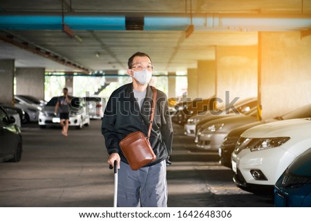 Man wearing mask for protect Novel Coronavirus:2019 or PM 2.5 dust and serious of the air pollution while walking with walking stick or crutches in car park.Covid-19 prevention.Prevention Concept