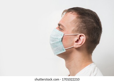 Man Wearing Medical Mask. Portrait Of Man In Surgical Mask On White Background. Side View