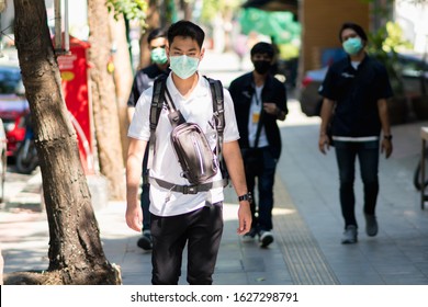 A man wearing mouth mask against air smog pollution PM 2.5 and Coronavirus at roadside in Bangkok, Thailand 2020.