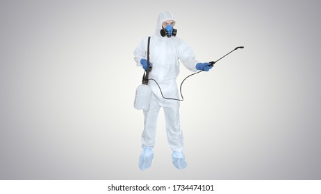 Man Wearing An NBC Personal Protective Equipment (ppe) Suit Spraying Disinfectant Water To Remove Covid-19 Coronavirus On Gradient Background.