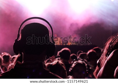 A man wearing a pair of headphones enjoying a silent disco.