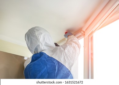 Man wearing protective biological suit and gas-mask due to mers coronavirus global pandemic warning and danger. Worker make disinfection, pest control and mold removal and ventilation at house room