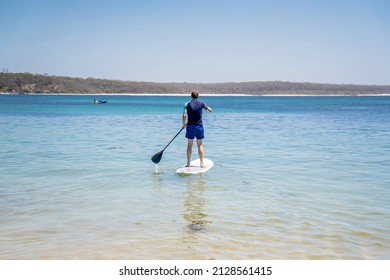 Man Wearing Rash Guard On A Stand-up Paddle Board At The Ocean Bay In Australia. SUP Water Sport Activity SUP Water Sport Summer Activity