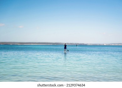 Man Wearing Rash Guard On A Stand-up Paddle Board At The Ocean Bay In Australia. SUP Water Sport Activity SUP Water Sport Summer Activity