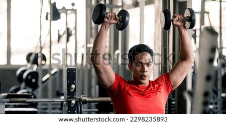 Man wearing red shirt lifting dumbbells in the gym, fitness gym, healthy exercise guidelines concept.